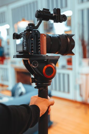 A vertical shot of a camera on a tripod in the room