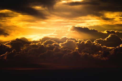 A breathtaking shot of clouds coming together and the sun shining through them during sunset