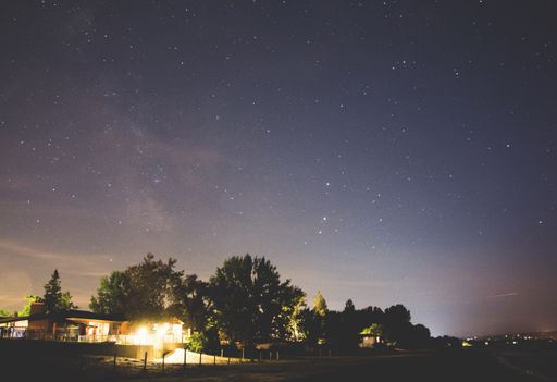 A beautiful shot of the night sky full of bright stars over a country scenery