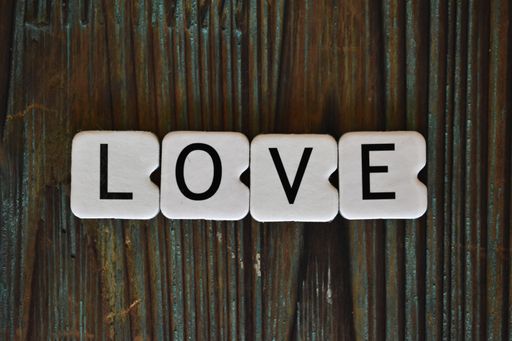 The word love written with white plastic letters on a wooden surface