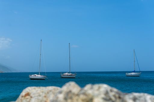A beautiful landscape shot of sailboats on calm waters under a clear blue sky
