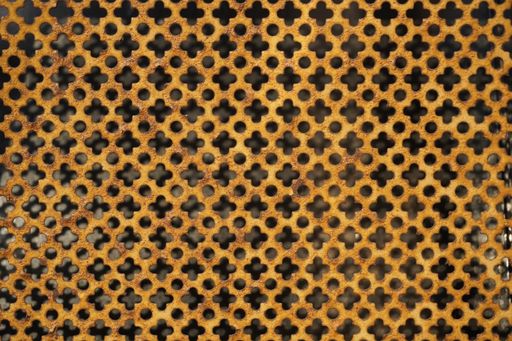 A closeup shot of a golden metal surface with dots and flower patterns