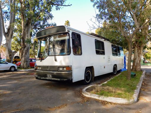 Quilmes, Argentina - May 29, 2022: Old white Mercedes Benz camper in a park. Nature, trees. Classic car show. Copyspace