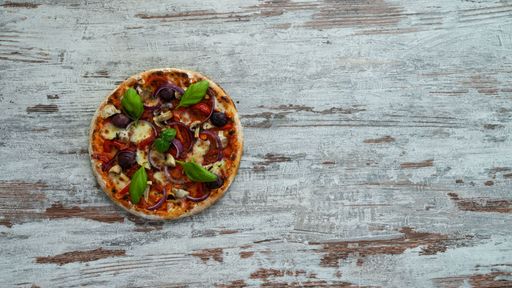 A top view of delicious pizza with mushrooms, basil and onion slices