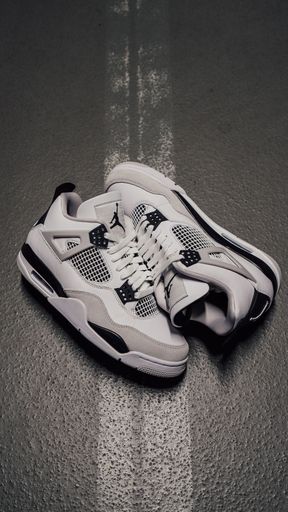 A vertical top view of Air Jordan 4 Retro "Military Black" shoes on asphalt road