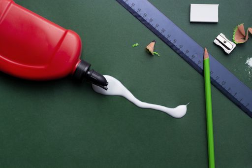 A high angle shot of school supplies on a green background