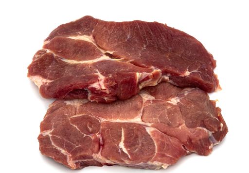 A closeup shot of raw pork neck isolated on a white background