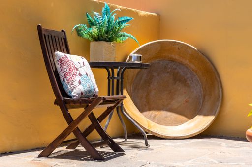 A wooden chair and table outside the lawn
