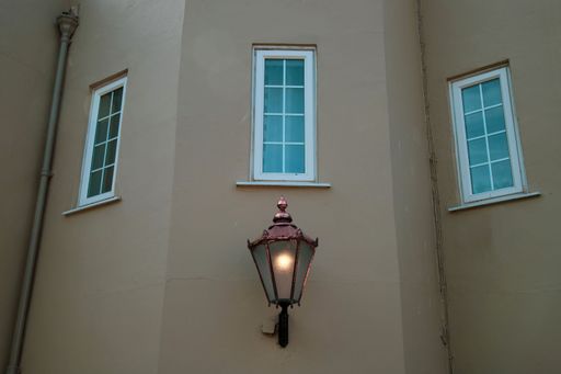 A beautiful lantern hanging on a wall under a window