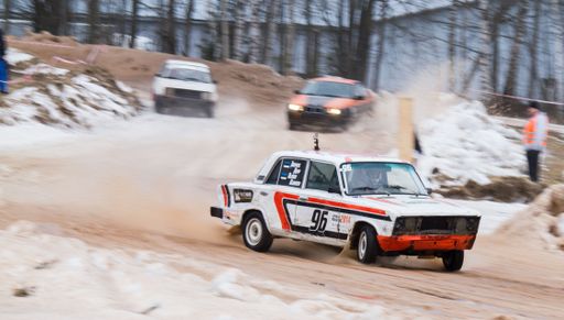 A race car on the track during rallycross ice racing in Estonia in selective focus with other vehicles blurred in the background