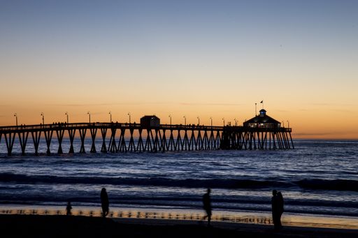 A beautiful shot of people walking on a pier over the sea during a breathtaking sunset
