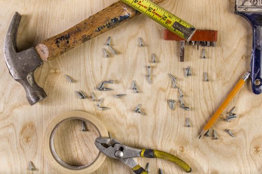 A high angle shot of different types of tools arranged on a wooden surface