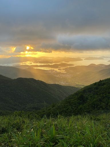 A vertical shot of a landscape in Hong Kong with mountains and a sunset