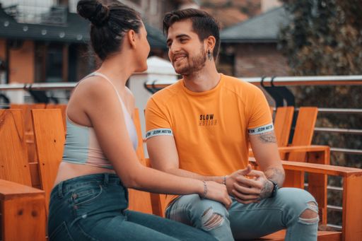 A shallow focus shot of a Caucasian male and female sitting intimately close to each other