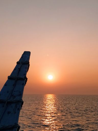 A scenic view of the sea under the orange sky at sunset