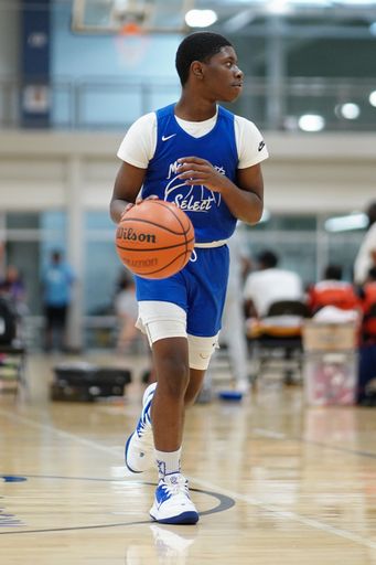 A black young boy holding and ready to pass the ball