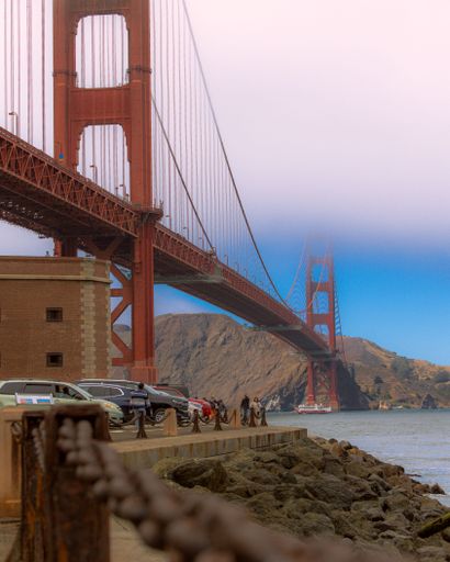 A vertical shot of the famous Golden Gate Bridge with visitors in San Francisco, United States