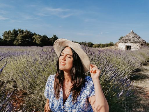 A beautiful young Caucasian woman in a straw hat posing in a lavender field