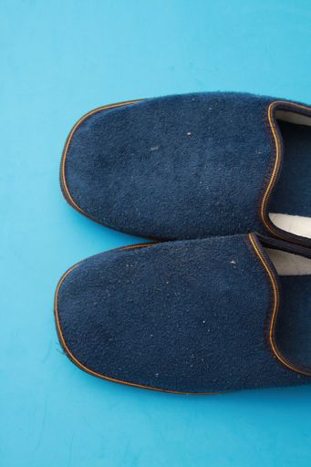 A high angle shot of blue slippers isolated on a light blue background