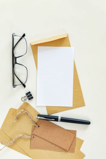 A Note paper, eyeglasses, envelopes, pen flat lay top view.