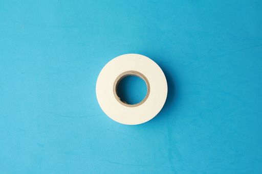 A flat lay shot of an adhesive tape on a blue surface