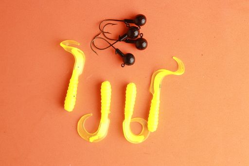 A high angle closeup shot of a set of fishing lures isolated on an orange background
