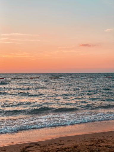 A vertical shot of a beach in the sunset