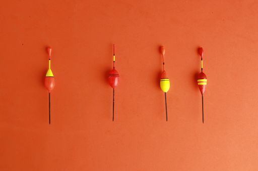A high angle shot of fishing floats isolated on an orange background