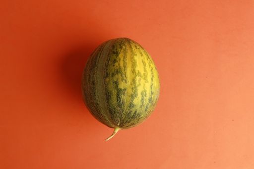 A closeup shot of a watermelon isolated on an orange background