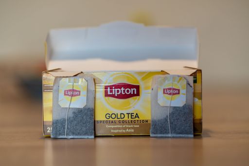 A close-up shot of Lipton brand Gold Tea bags and an open box on a table