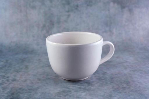 A closeup shot of a small white mug isolated on a gray background