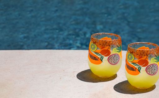 A beautiful view of two glasses of juice near the pool