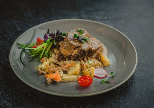A close-up shot of roasted beef with vegetables on a plate
