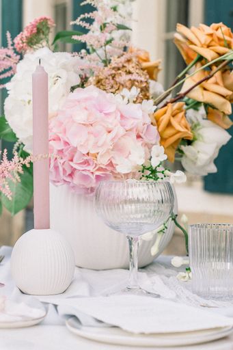 A closeup shot of candles and flowers on a table for a wedding