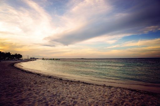 A breathtaking shot of a sunrise at the ocean with calm waves moving towards the shore