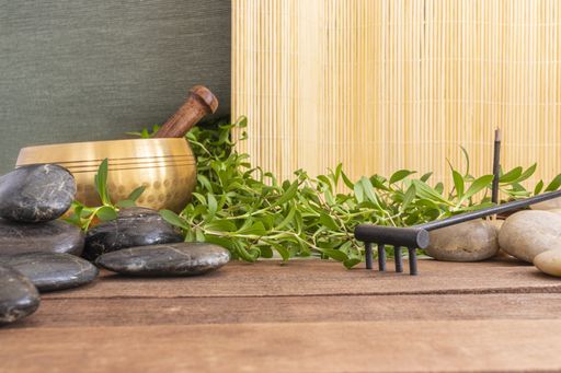 A closeup shot of the rocks and plants used in massage and meditation on a wooden surface