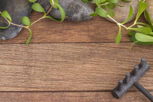 A high angle shot of the rocks and plants used in massage and meditation on a wooden surface