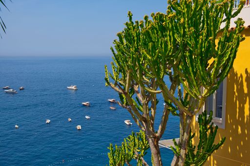 An aerial view of boats on the blue sunny sea of Positano, Italy