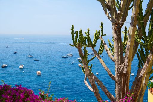 An aerial view of boats on the blue sunny sea of Positano, Italy