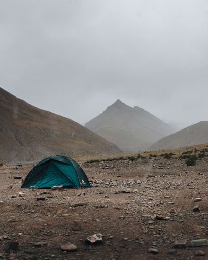A Green tent in the Himalayan mountains on a foggy day