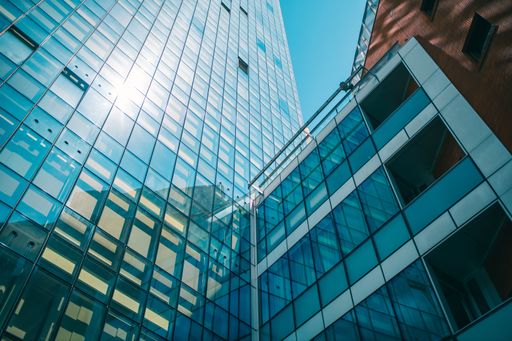 A low angle shot of a business building with glass walls under the sunlight