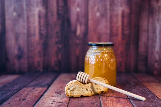 A closeup of a honey jar in a wooden box