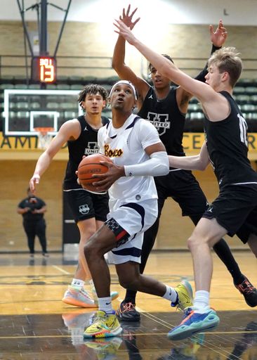 A vertical of African Americans playing basketball at Bosco vs United Prep game in Hammond, Indiana