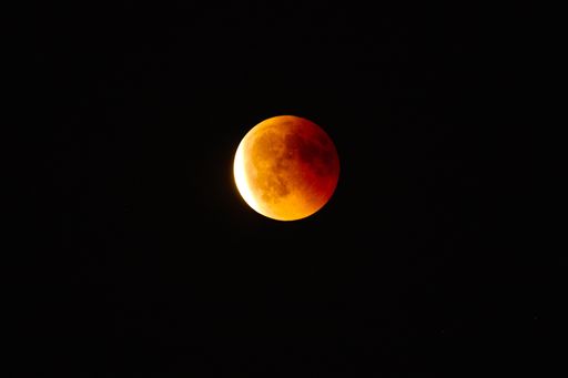 The orange and red-colored full moon captured at night