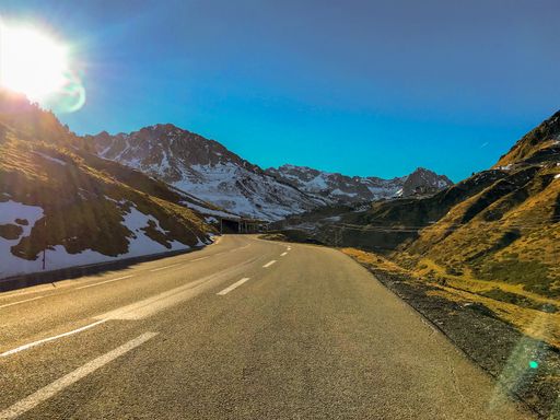 precioso dia soleado subiendo el puerto del tourmalet en francia con las montagnas medio nevadas y una luz preciosa reflejando la carretera