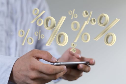 The man holding the smartphone with the virtual percentage icons above the screen. Sales concept