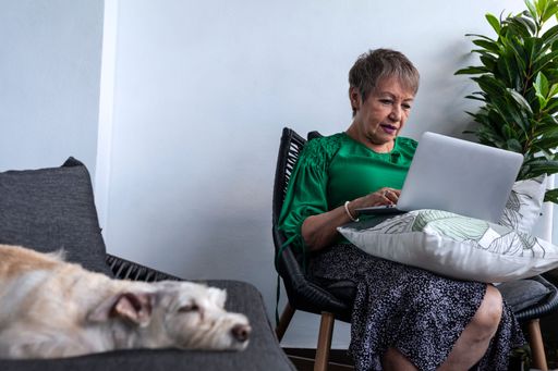 An old Hispanic female working from home in front of her laptop