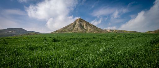 A breathtaking view of mountains in a green area
