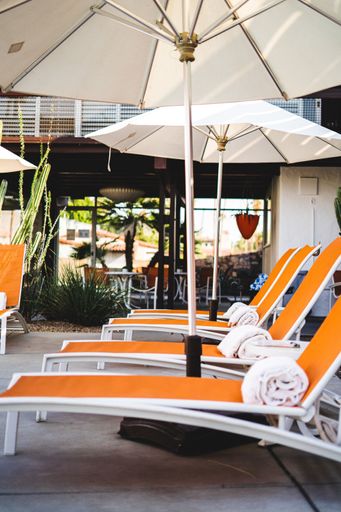 A vertical shot of sun loungers with rolled towels on the poolside in Palm Springs. California.
