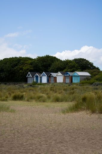 A row of colorful beach huts on a sandy beach